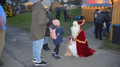Der Nikolaus verschenkt Schokolade an ein Kind
