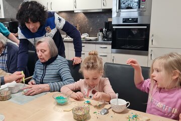 Kinder backen mit Seniorinnen Plätzchen
